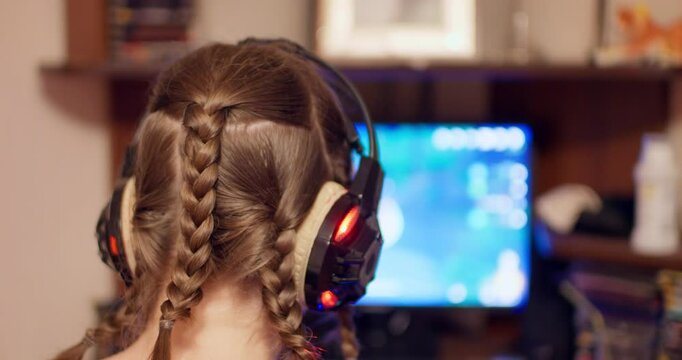 Girl with pigtails in headphones playing a cosplay game back view