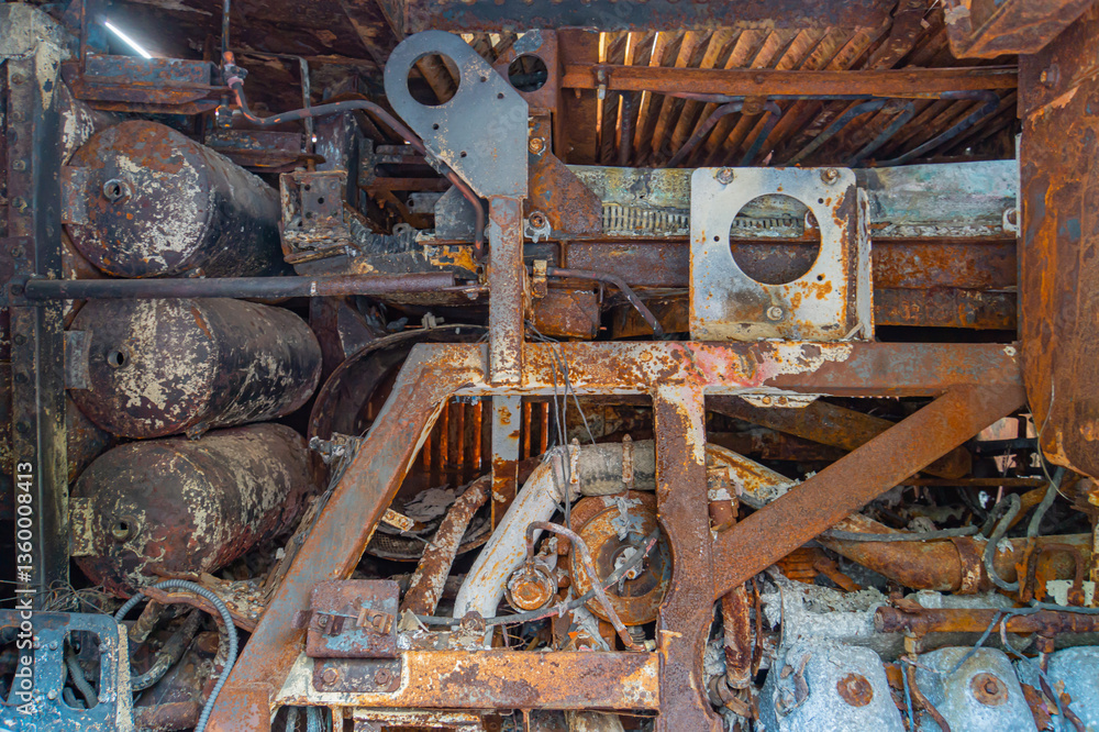 Poster close-up view of an aged, industrial scene with rusted metal structures and components the image fea