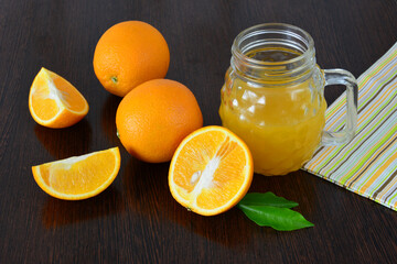 Orange juice and fresh oranges on a wooden table