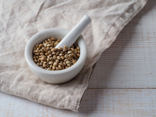 Hemp seeds in the bowl on wooden background.