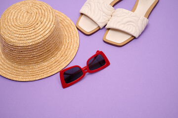 straw hat with sunglasses, light shoes on a pink background. Beach vacation.