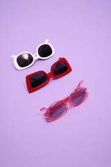 different sunglasses on a pink background, vision test, stylish glasses concept.