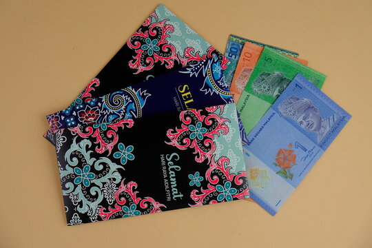Money packet or translated as sampul duit raya in Malay with Ringgit Malaysia Notes for Ramadhan and Eid Fitr Celebration on isolated background. Selective focus. known as Duit raya 