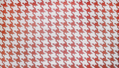 close-up shot of a beige and red houndstooth pattern on a woven fabric, showcasing the classic textile design suitable for fashion and interior applications, repeating  pattern background.