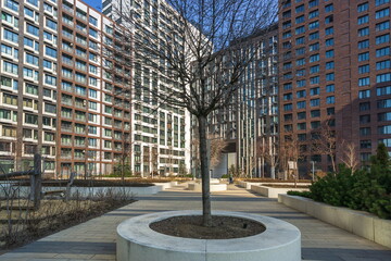 A central circle with a decorative light post is surrounded by green grass and trees in a...