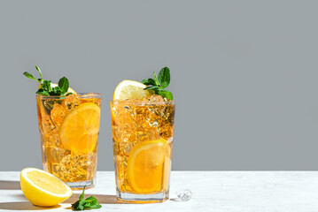 Glasses of iced tea with lemon slices, mint and ice