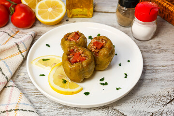 Biber dolma - Biber dolması stuffed peppers on white rustic wood