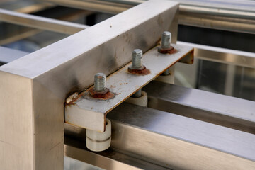 Rusty screws securing metal plate on industrial equipment