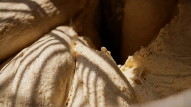 Industrial dough mixer in operation close-up of the kneading process in a bakery, preparing dough for artisan bread and delicious pastries. High quality 4k footage
