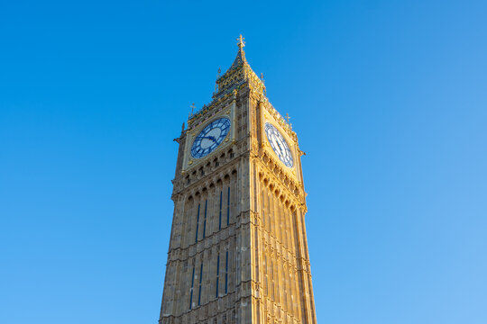 Big Ben stands tall against a vibrant blue sky in London, showcasing its intricate architecture. The clock tower is a symbol of British heritage and attracts many visitors.