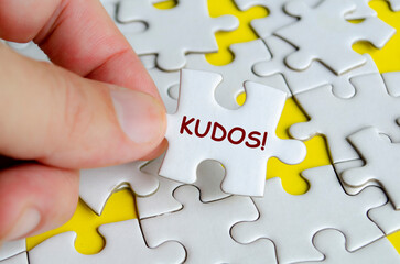 KUDOS text on missing jigsaw puzzle. Outstanding achievement concept