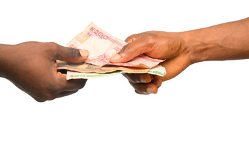 A close-up of two hands exchanging Nigerian Naira banknotes, symbolizing trade, business, financial...