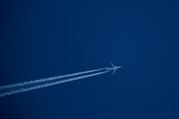 Airplane in the blue sky with contrail