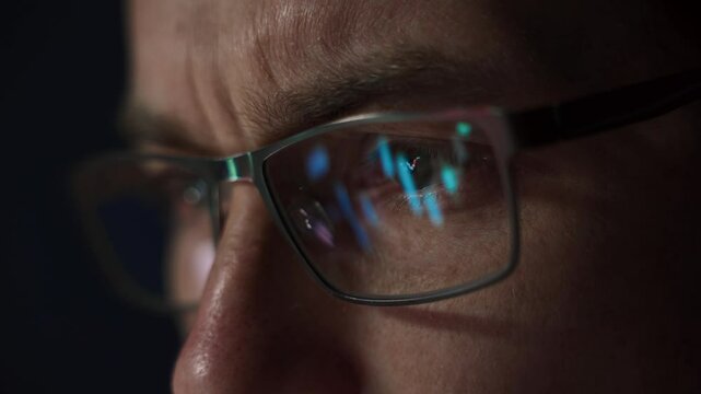 close up of professional trader closely monitors financial analytics, with forex and stock market charts reflected in his eyeglasses, assessing crypto market movements. 