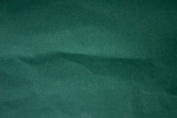 Abstract crumpled dark green paper background creased texture
