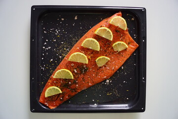 A whole red salmon filet with lemon and herbs