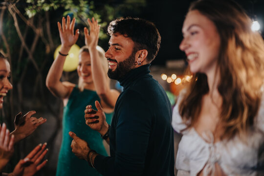 A joyful gathering of friends experiencing a memorable evening party outdoors, enjoying each other’s company and celebrating the occasion under the festive lights.