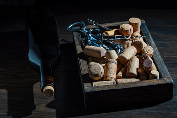 Wine corks, corkscrew and bottle on wooden table, closeup