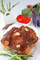 Delicious roast meat with garlic and herbs, served with fresh vegetables and wild garlic rampson on a white plate