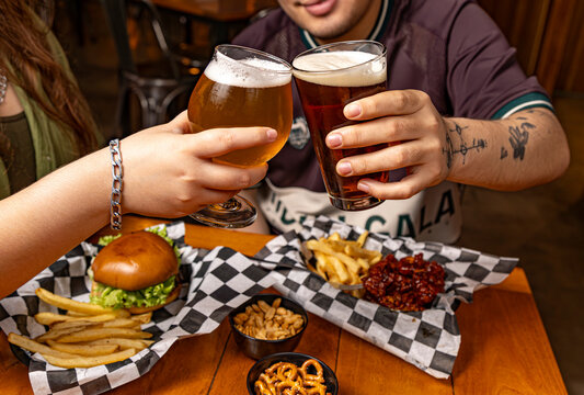 Brindis con cervezas y comida en un sport bar