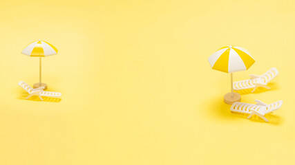 Sun lounger and yellow umbrella on a yellow background.