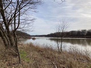 river in the forest with fishermen in distance