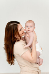 a mother with a baby on a white isolated background, a place for text, a young mother gently hugs her little child, a girl in diapers, maternal love and care