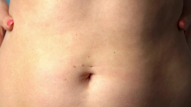 Woman in close-up shows fat measurement