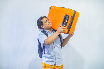 Portrait Asian muslim man carrying suitcase . Concept Going home for Eid Mubarak. Isolated image on white background