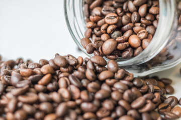 Coffee beans spilling out of a glass jar