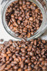 Coffee beans spilling out of a glass jar