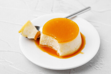 Tasty pudding with caramel sauce served on white textured table, closeup