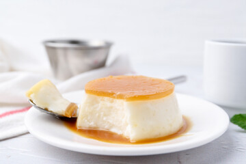 Tasty pudding with caramel sauce served on white textured table, closeup