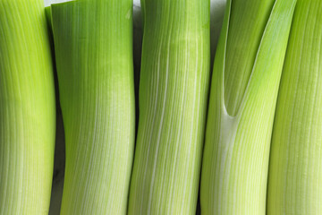 Whole fresh leeks as background, top view