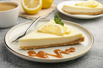 Pieces of delicious lemon cheesecake served on grey textured table, closeup