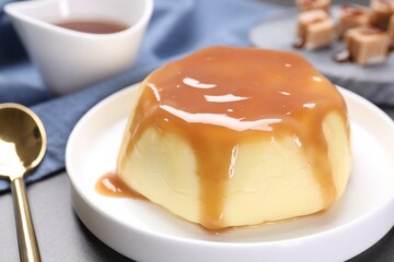 Delicious pudding with caramel sauce served on table, closeup
