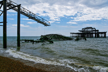 Fototapeta premium Remains of old burned Brighton pier in the sea near beach
