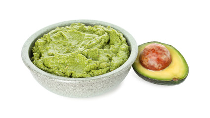 Tasty avocado dip in bowl and fruit isolated on white