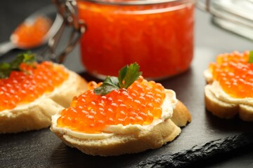 Tasty sandwiches with red caviar on table, closeup
