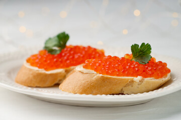 Tasty sandwiches with red caviar on white wooden table, closeup
