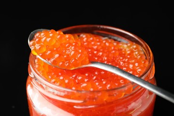 Delicious red caviar on black background, closeup