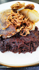 Roasted duck leg with crispy onions, dumpling and red cabbage in czechia restaurant