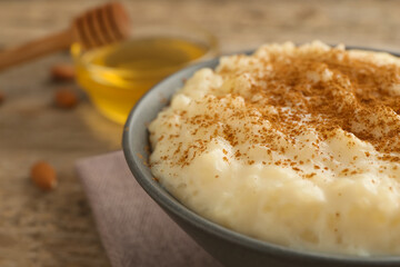 Delicious rice pudding with cinnamon on wooden table, closeup
