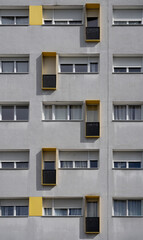 Paris, France - 03 22 2025: View detail of a graphical yellow and gray facade building with balconies and shadows .