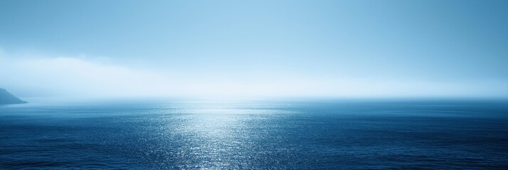 Obraz premium An expansive view of serene waters beneath a soft mist creates a peaceful and tranquil atmosphere.