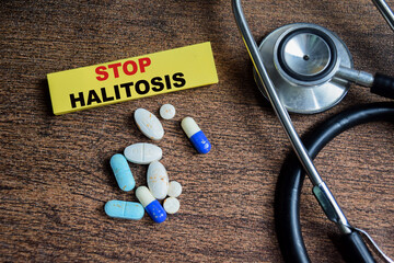 Concept of Stop Halitosis write on sticky notes isolated on Wooden Table.