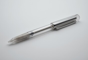 Silver ballpoint pen lying on a white background  