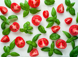 Tomatoes and basil leaves on white marble background, top view