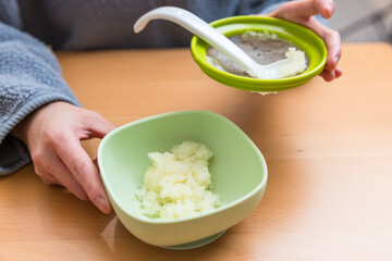 Parent making mashed food for baby feeding
