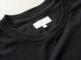 Black t-shirt featuring a blank white label and ribbed neckline. Ideal for branding, mockups, and apparel design.